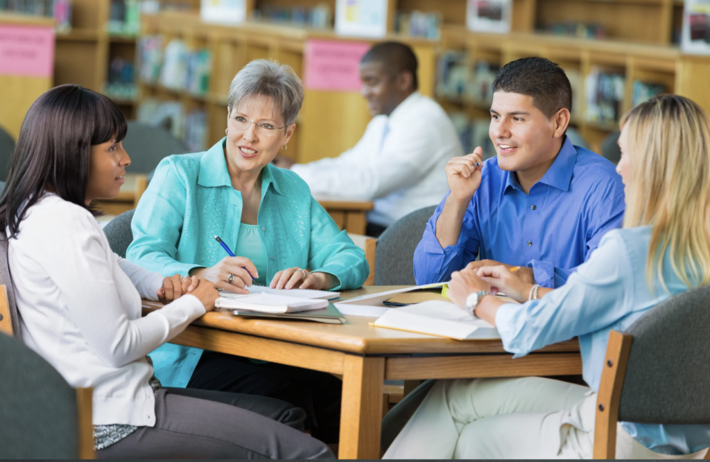 teachers in a room having 5 five safety conversations before doors open